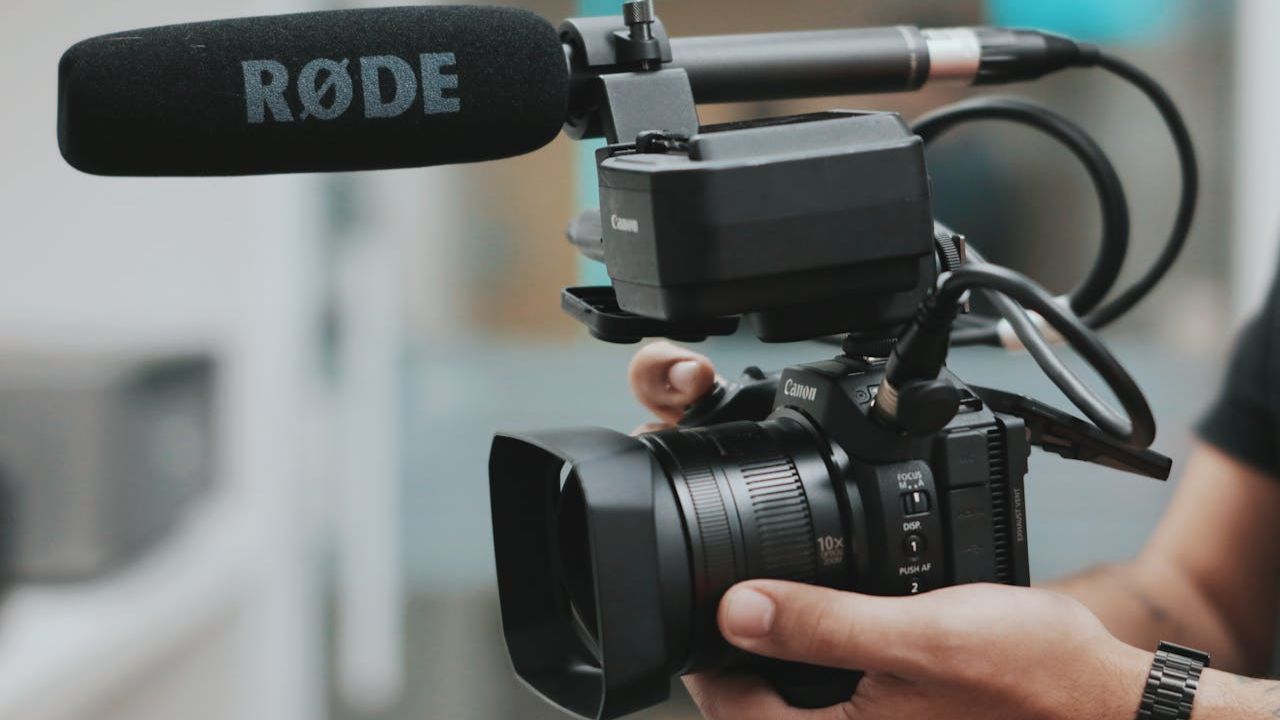 Handheld camera with rode mic.